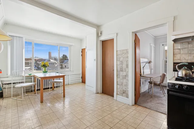 a living room with furniture a dining table and a refrigerator