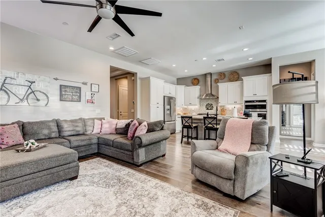a large kitchen with granite countertop a sink and a stove top oven with wooden floor