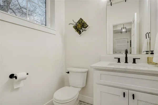 a bathroom with a sink vanity mirror and toilet