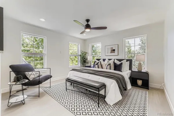 a spacious bedroom with a bed a couch and a window