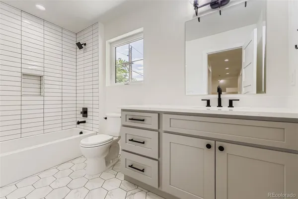 a bathroom with a toilet a sink a mirror and a bathtub