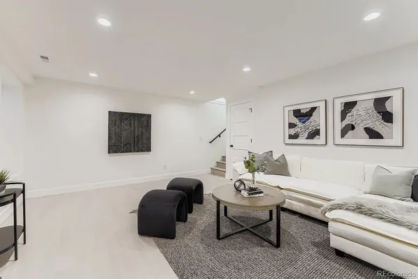 a living room with furniture and a painting on the wall