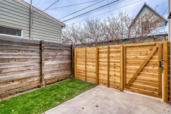 a view of backyard with wooden fence and large windows