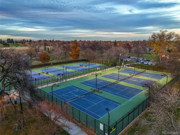 a view of a tennis ground with trees in the background