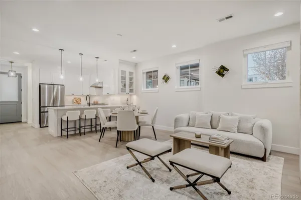 a living room with lots of furniture and kitchen view