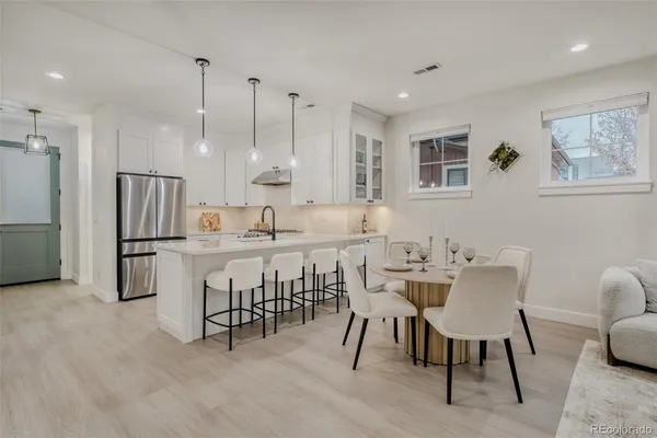 a kitchen with kitchen island white cabinets and stainless steel appliances