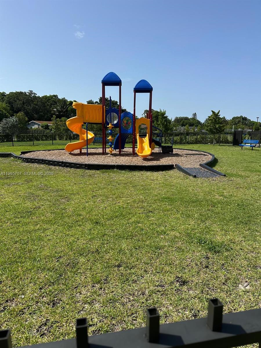 12221 Northwest 23rd Place Miami, FL 33167 - Photo 17 of 17 a view of a lake with a table and chairs next to a yard