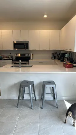 a kitchen with stainless steel appliances a stove a sink cabinets and a dining table