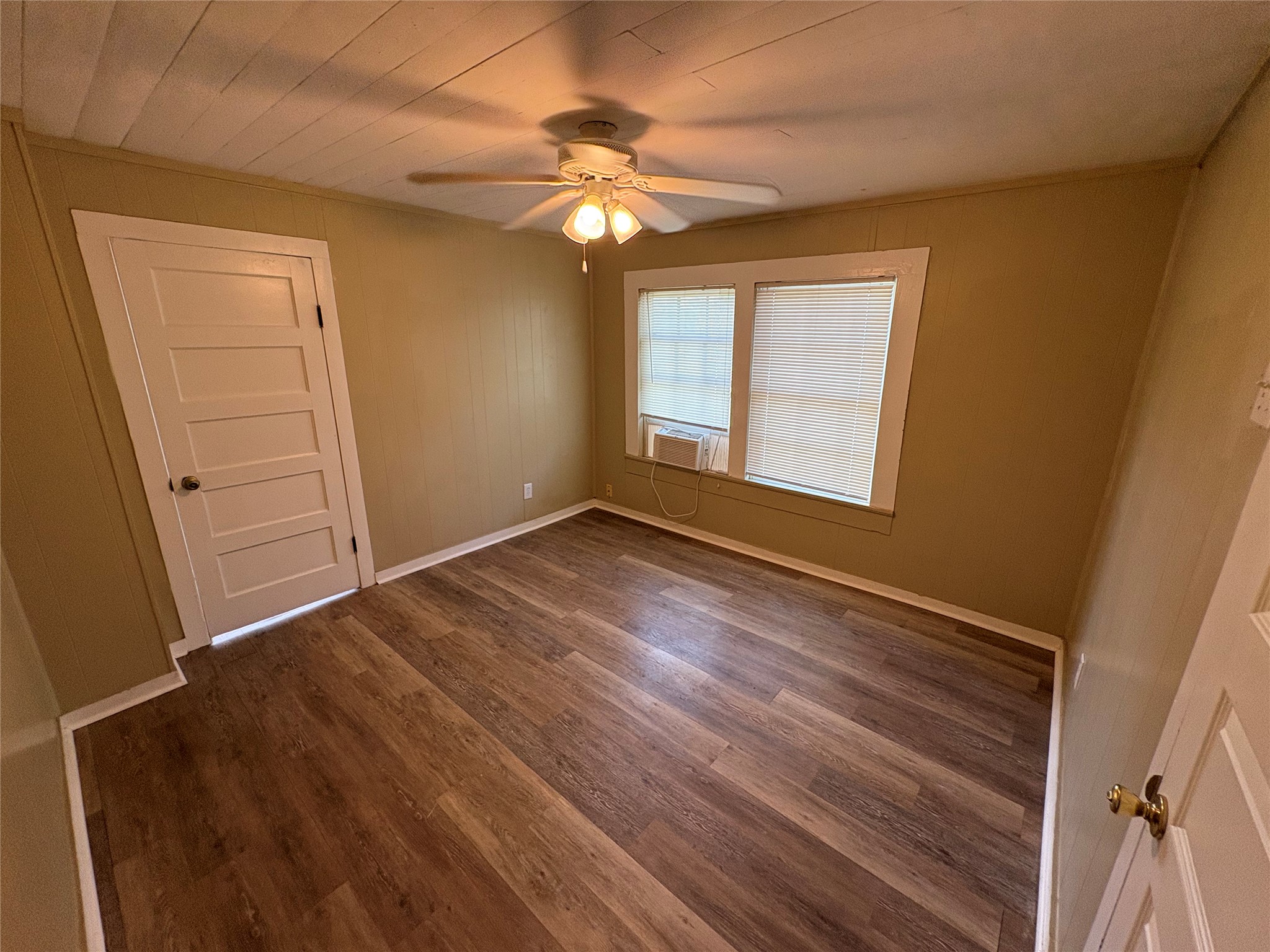 2305 Main Street Bastrop, TX 78602 - Photo 4 of 11 A comfortable bedroom with wood-look flooring and a functional ceiling fan for year-round comfort.