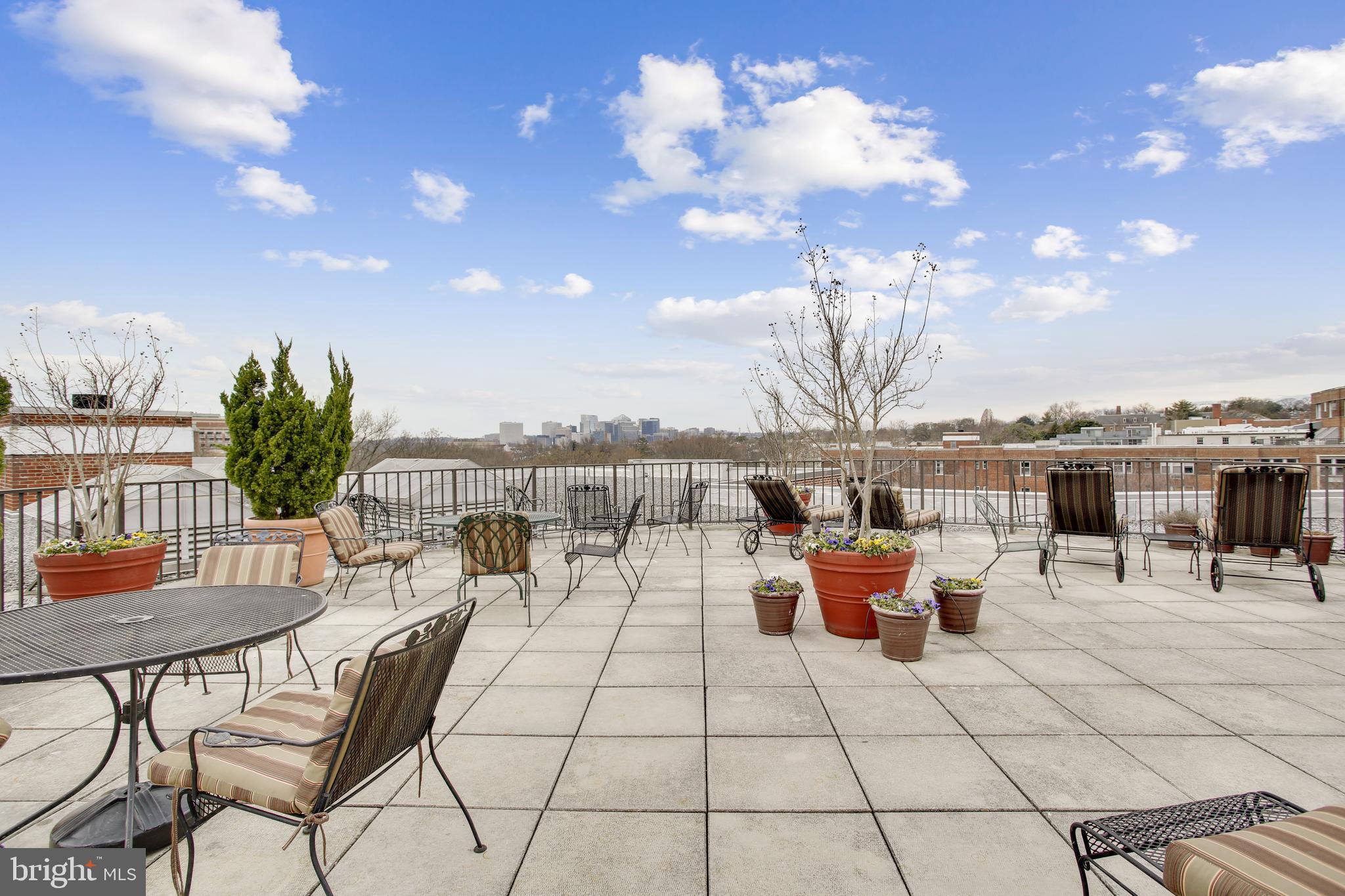 2500 Q Street Northwest, Unit 201 Washington, DC 20007 - Photo 13 of 36 a roof deck with table and chairs couches with wooden floor