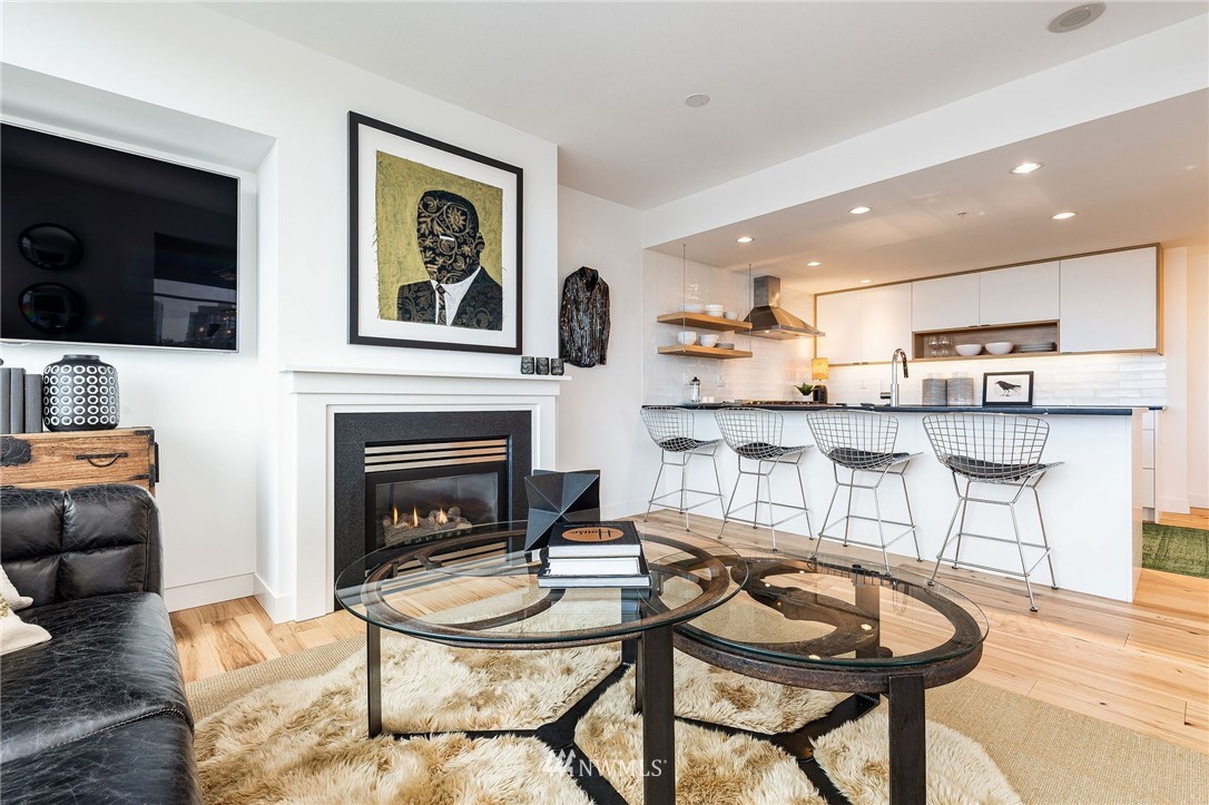 1420 Terry Avenue, Unit 2602 Seattle, WA 98101 - Photo 11 of 40 a living room with stainless steel appliances furniture a fireplace and flat screen tv