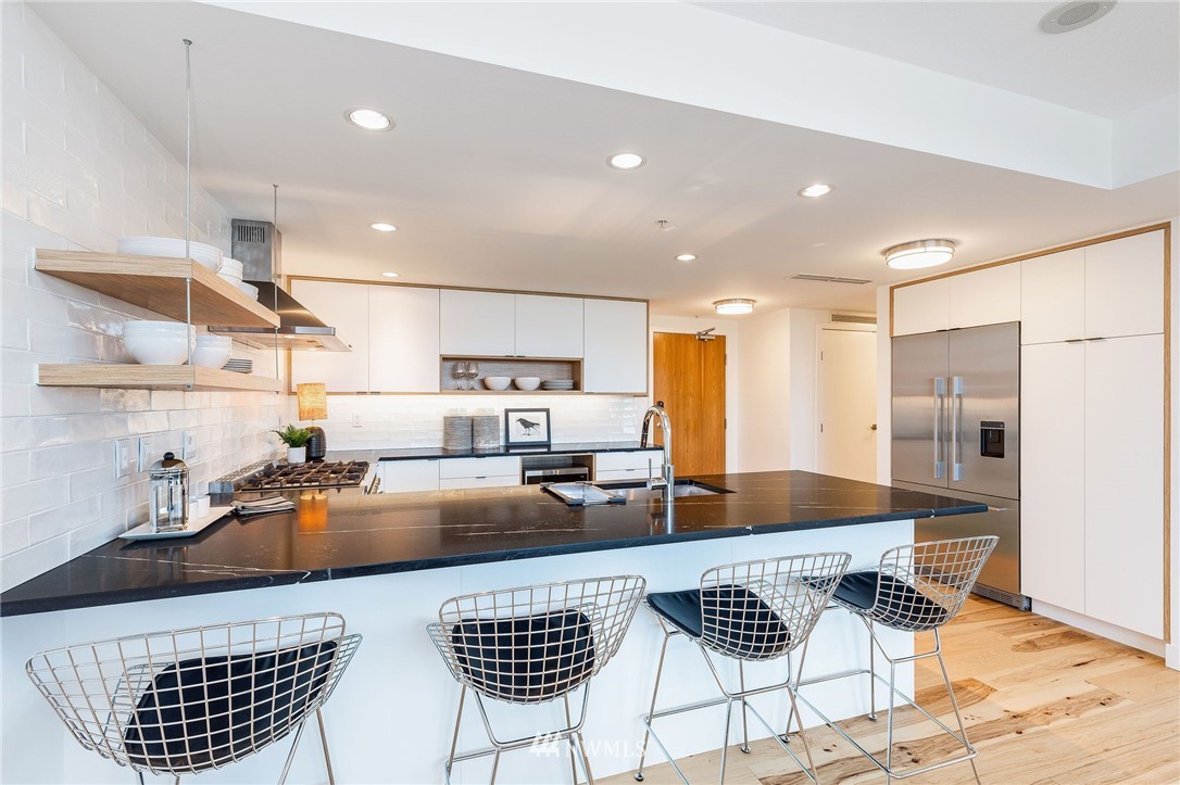 1420 Terry Avenue, Unit 2602 Seattle, WA 98101 - Photo 12 of 40 a kitchen with stainless steel appliances granite countertop a sink a stove a refrigerator cabinets and chairs