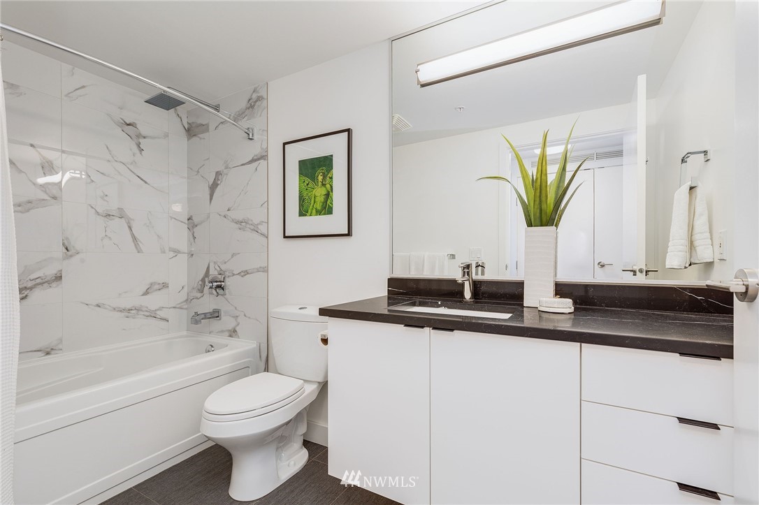 1420 Terry Avenue, Unit 2602 Seattle, WA 98101 - Photo 28 of 40 a bathroom with a granite countertop sink a toilet and bathtub
