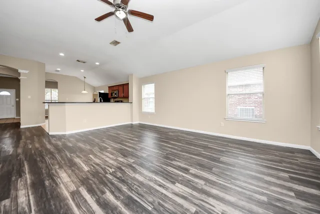 a kitchen with stainless steel appliances granite countertop a sink a stove top oven a refrigerator a sink with a dining table and chairs