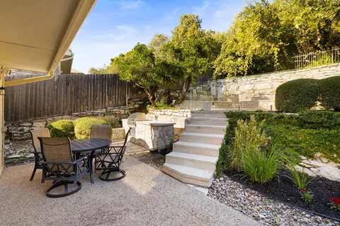 a view of a patio with table and chairs and potted plants