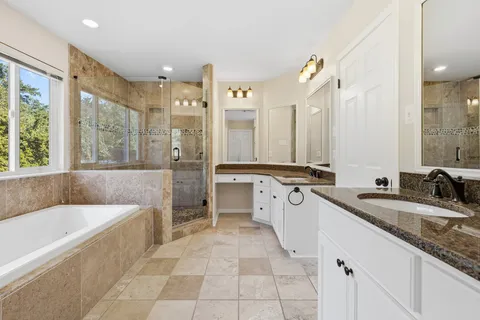a white bath tub sitting in a bathroom next to a window