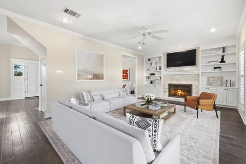 a living room with furniture a flat screen tv and a fireplace
