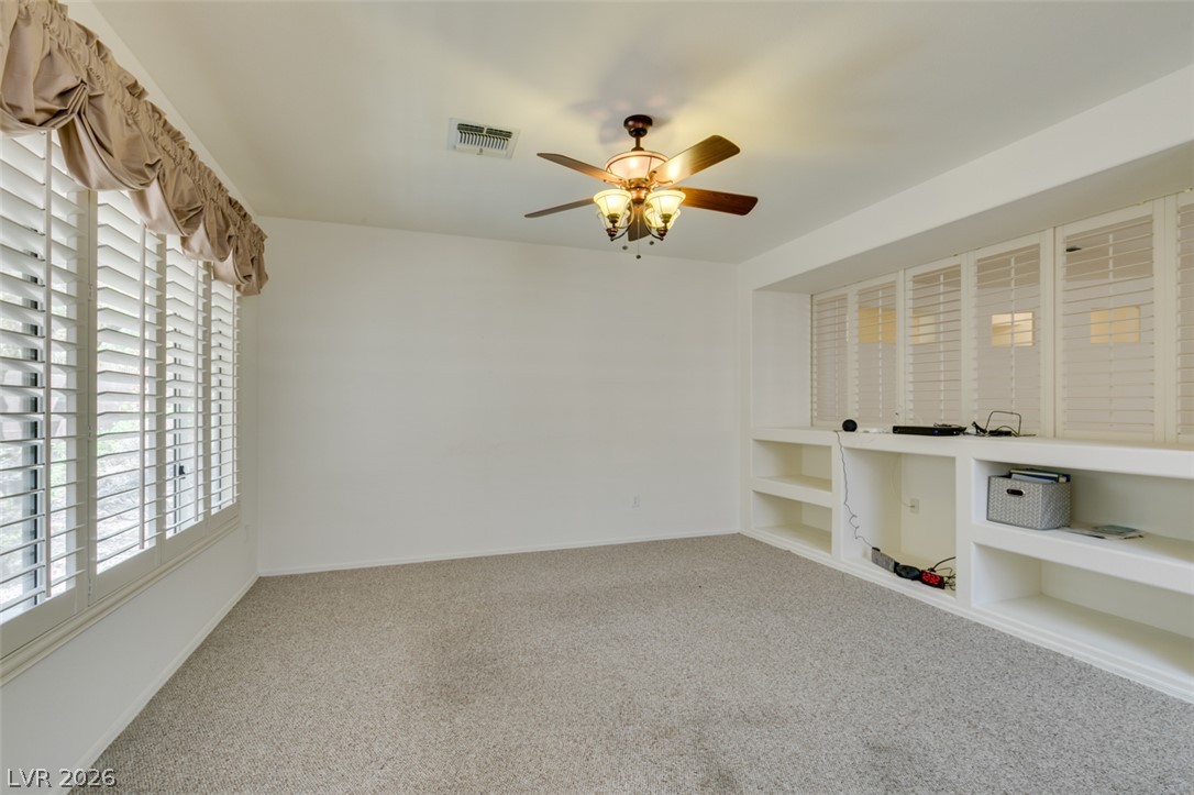 2189 Chapman Ranch Drive Henderson, NV 89012 - Photo 18 of 60 Custom built-in shelving and plantation shutters define this versatile carpeted room.