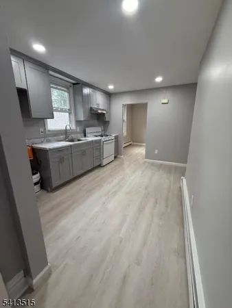 a large kitchen with a lot of counter space and wooden floor