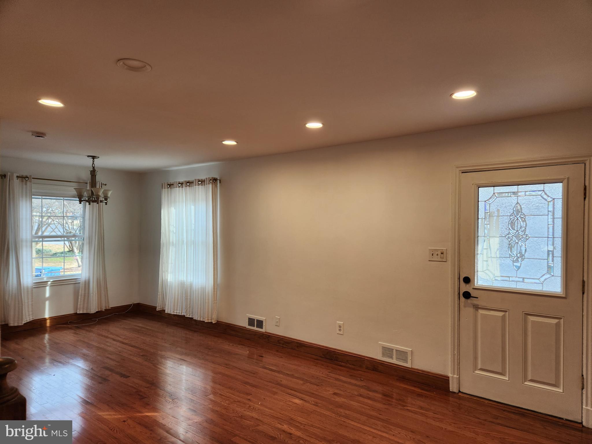 502 East Schuyler Road Silver Spring, MD 20901 - Photo 4 of 38 a view of an empty room with wooden floor and windows