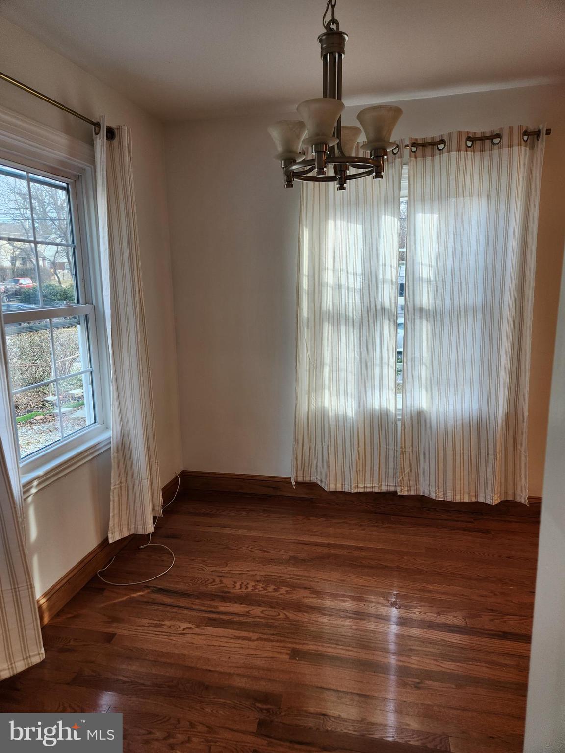 502 East Schuyler Road Silver Spring, MD 20901 - Photo 6 of 38 an empty room with wooden floor a ceiling fan and windows