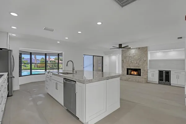 a large kitchen with stainless steel appliances granite countertop a large counter top and a fireplace