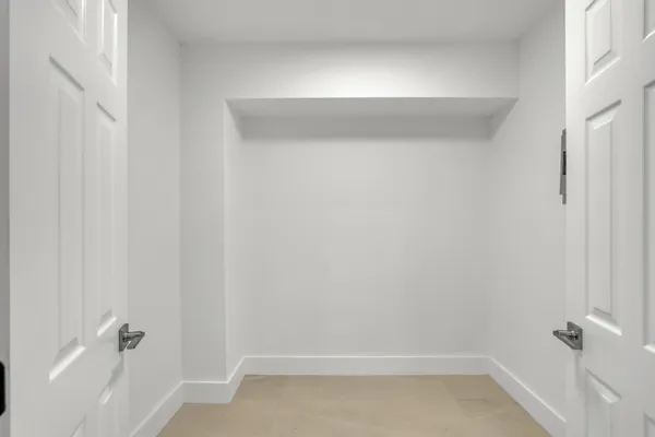 an empty room with windows and ceiling fan