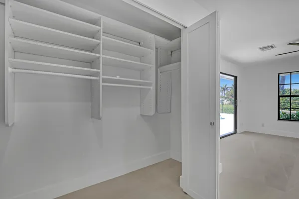 an empty room with ceiling fan and window