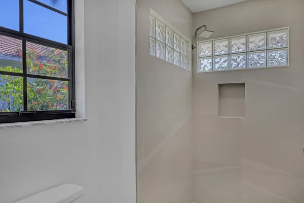 a bathroom with a toilet a sink a mirror and a shower