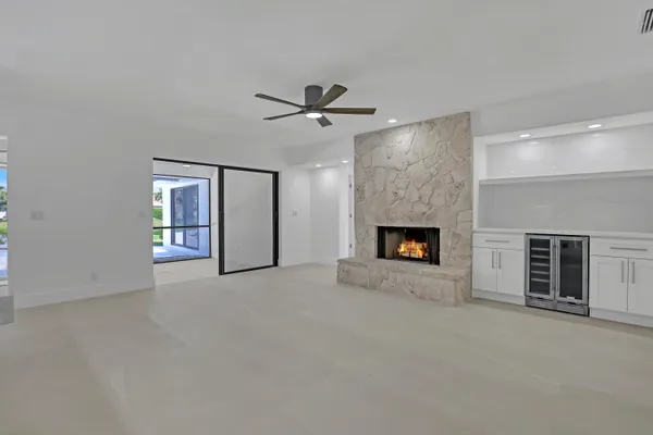 an empty room with windows and fireplace