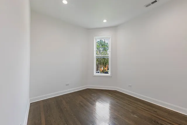 an empty room with wooden floor and window