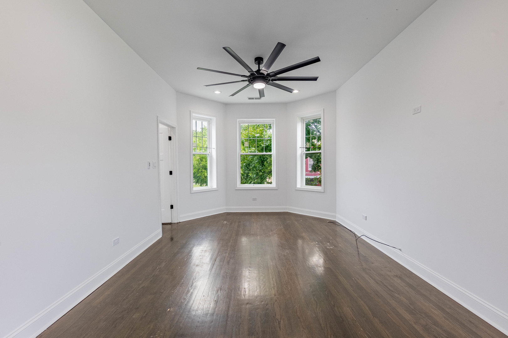 4453 West Adams Street Chicago, IL 60624 - Photo 6 of 32 an empty room with wooden floor windows and fan
