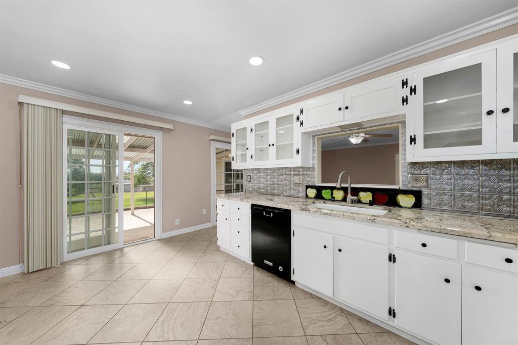 2073 Valley Rim Road El Cajon, CA 92019 - Photo 12 of 33 a kitchen with granite countertop a stove a sink and white cabinets with wooden floor