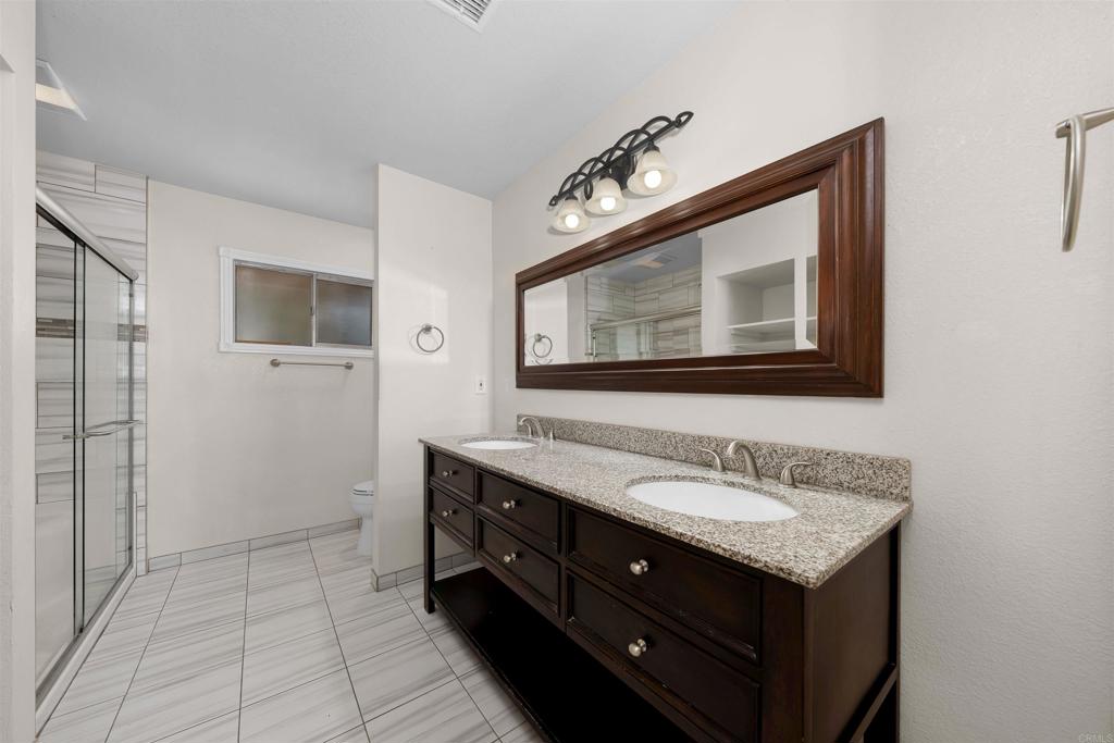 2073 Valley Rim Road El Cajon, CA 92019 - Photo 16 of 33 a bathroom with a sink vanity and a mirror
