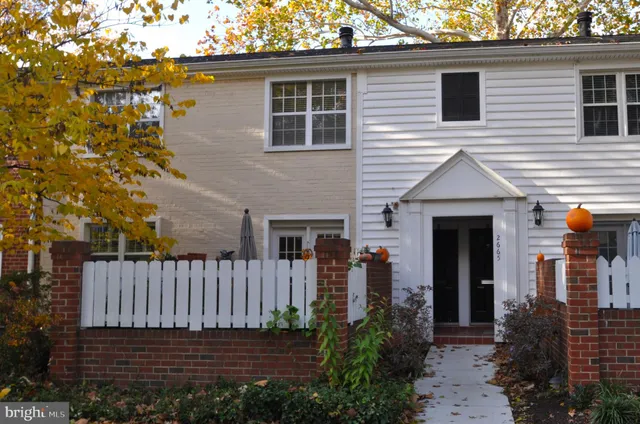 a view of a house with a small yard and wooden fence