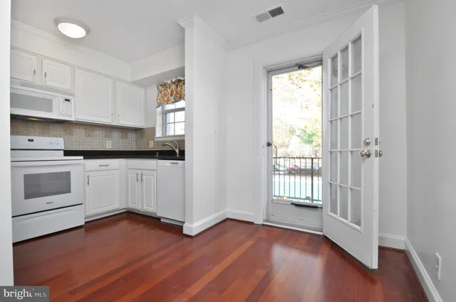a kitchen with wooden floors and white appliances