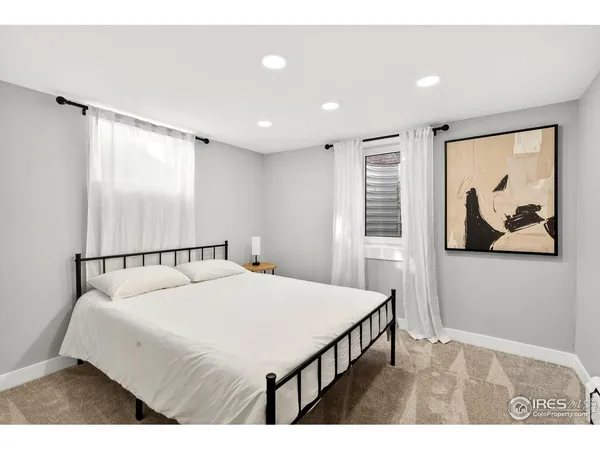 a bedroom with a bed and a painting on the wall