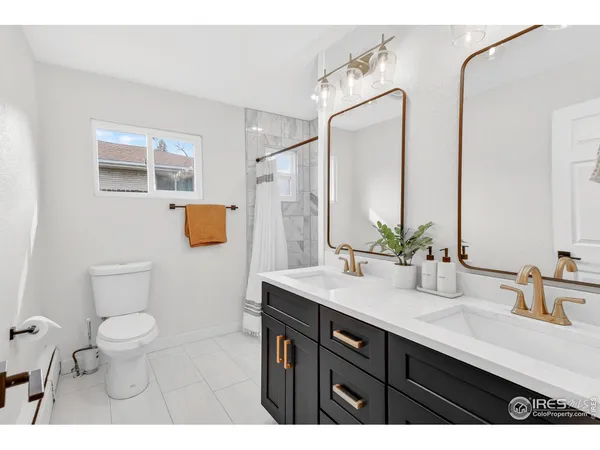 a bathroom with a sink a toilet a mirror and shower