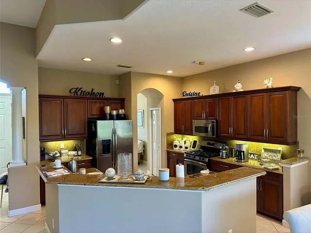 a kitchen with sink refrigerator and cabinets