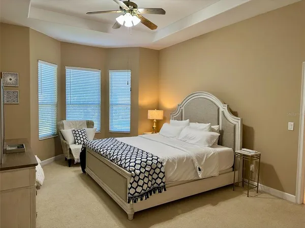 a bedroom with a bed chairs and window