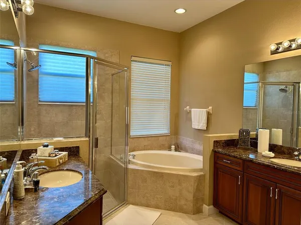a bathroom with a granite countertop sink and a bathtub
