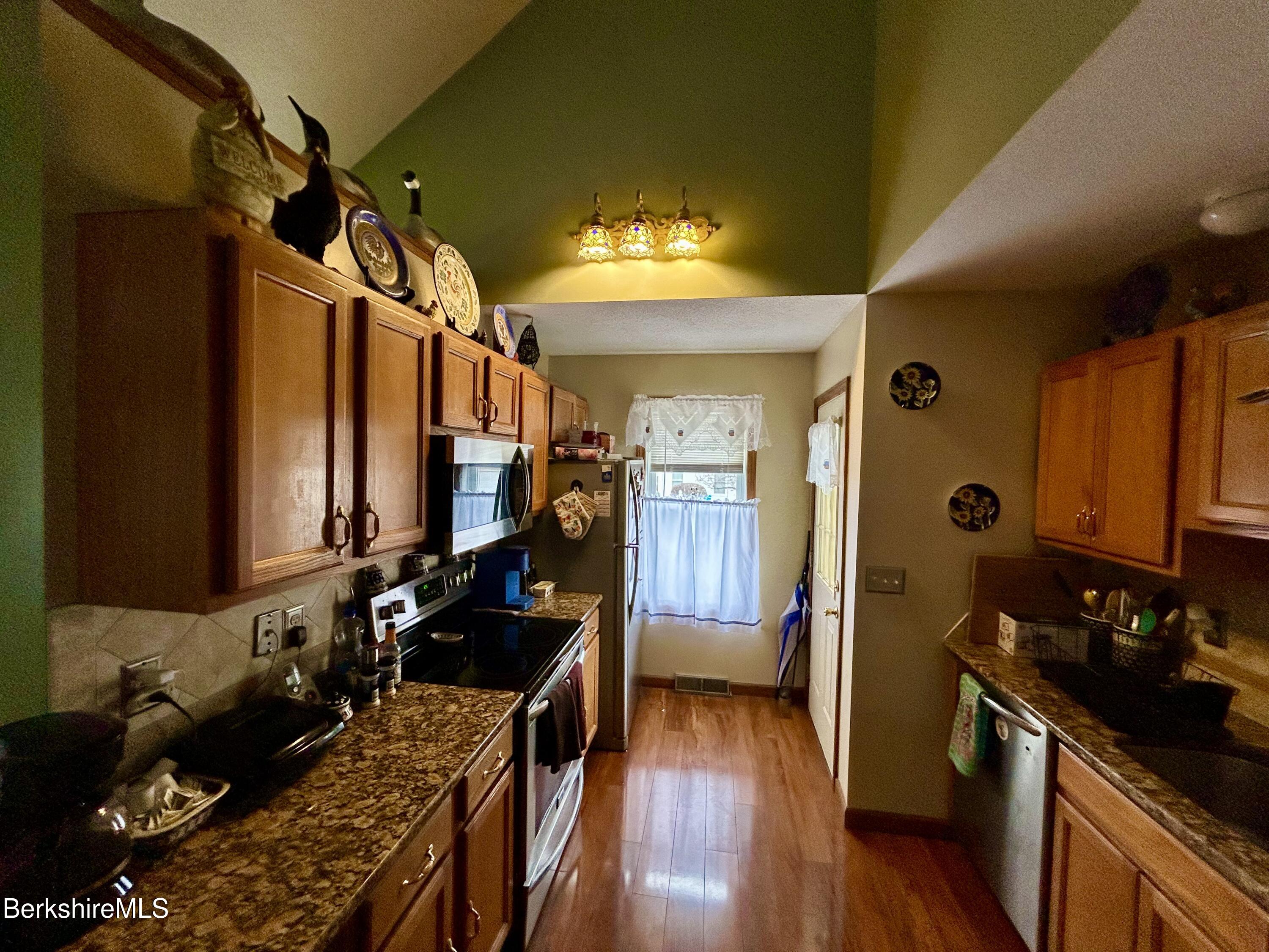 20 Richmond Way Chicopee, MA 01022 - Photo 6 of 25 a kitchen with granite countertop a stove and a wooden floor