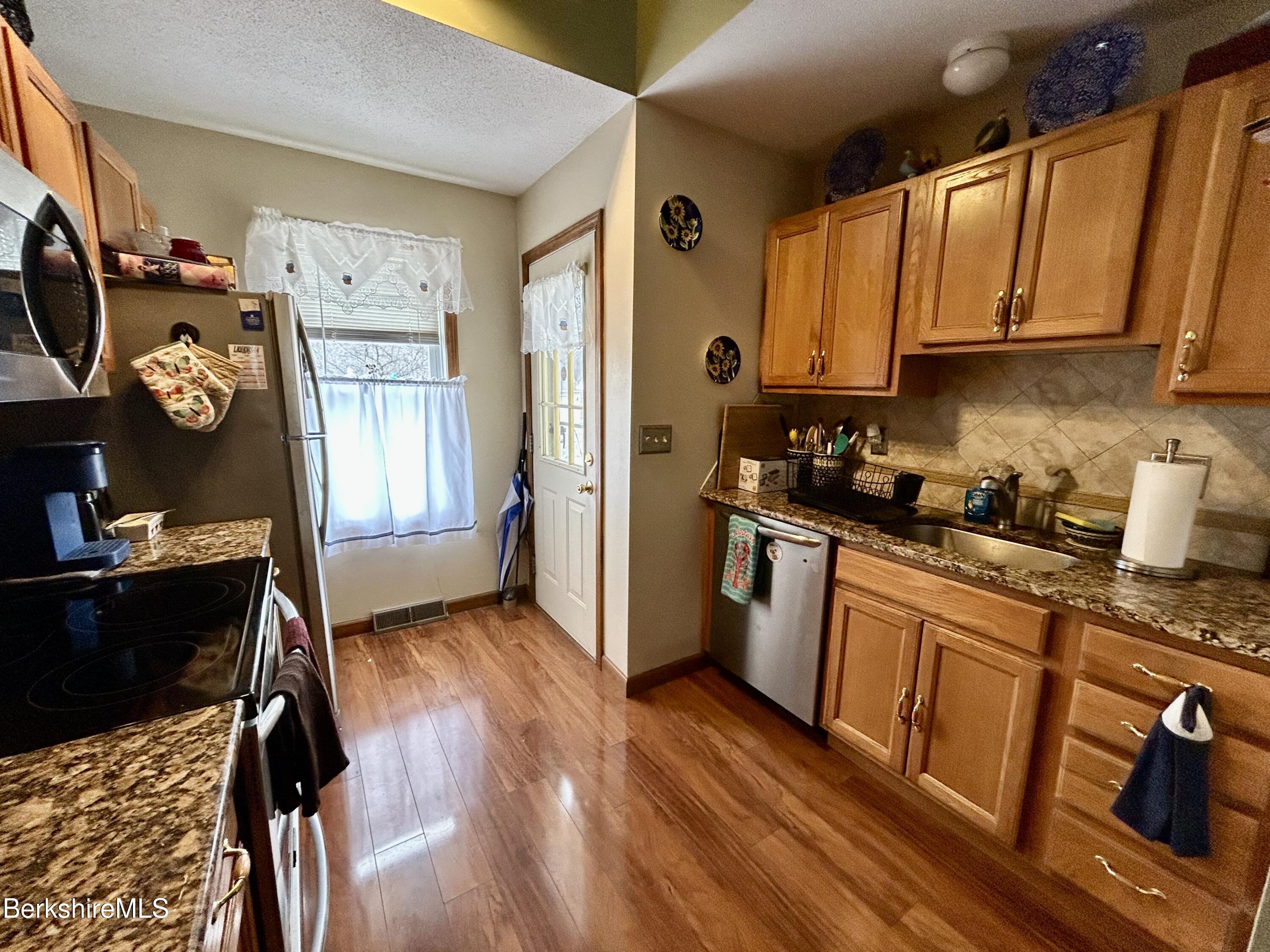 20 Richmond Way Chicopee, MA 01022 - Photo 8 of 25 a kitchen with stainless steel appliances granite countertop a refrigerator a stove top oven a sink and dishwasher
