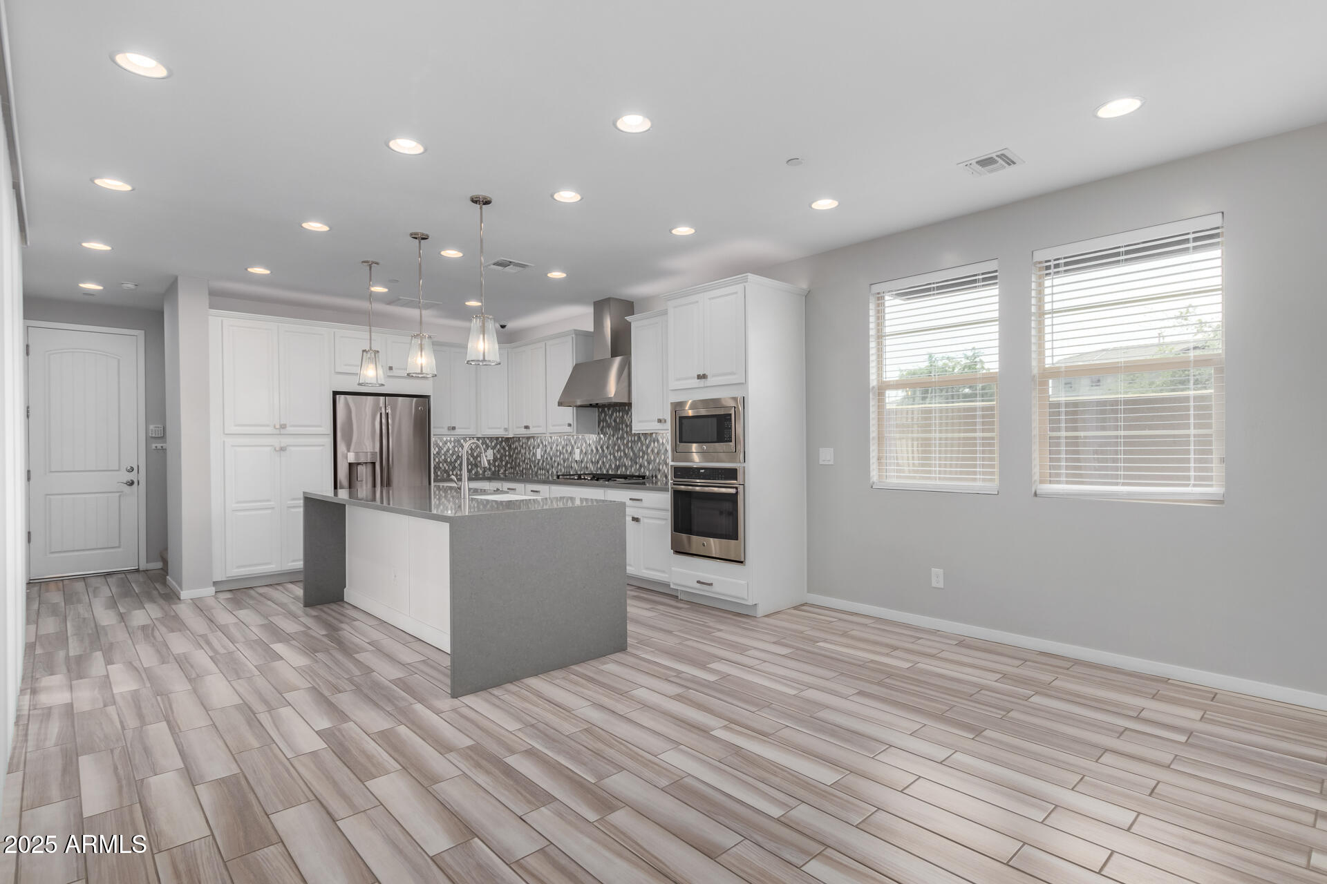 1848 South Follett Way Gilbert, AZ 85295 - Photo 26 of 32 a large kitchen with kitchen island a sink wooden floor and stainless steel appliances