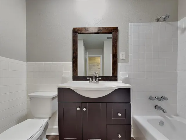 a bathroom with a sink a toilet and mirror