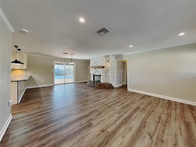 a view of empty room with wooden floor
