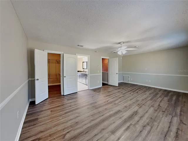 a view of empty room with wooden floor