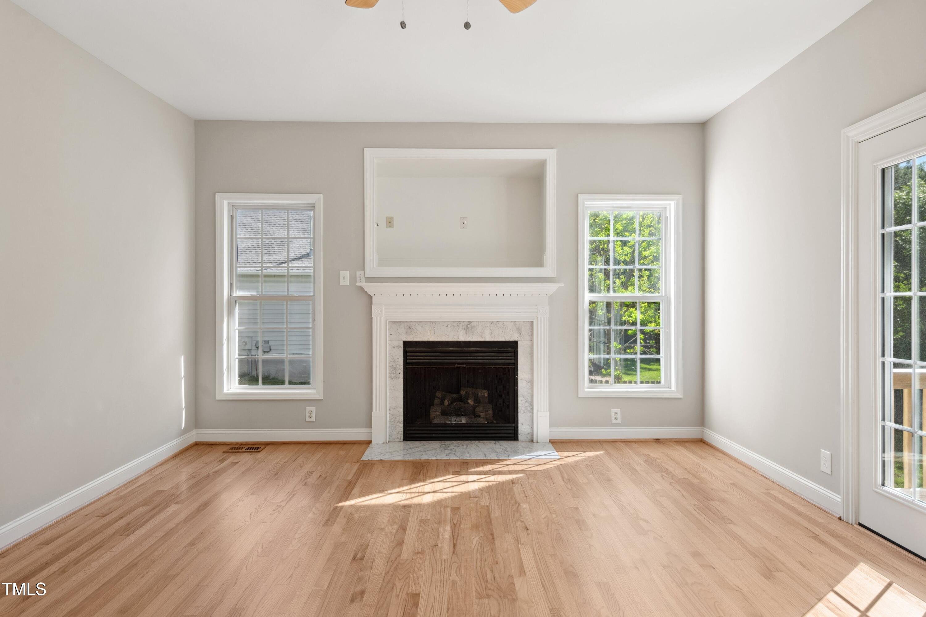 1909 Redding Lane Durham, NC 27712 - Photo 18 of 49 an empty room with windows and fireplace