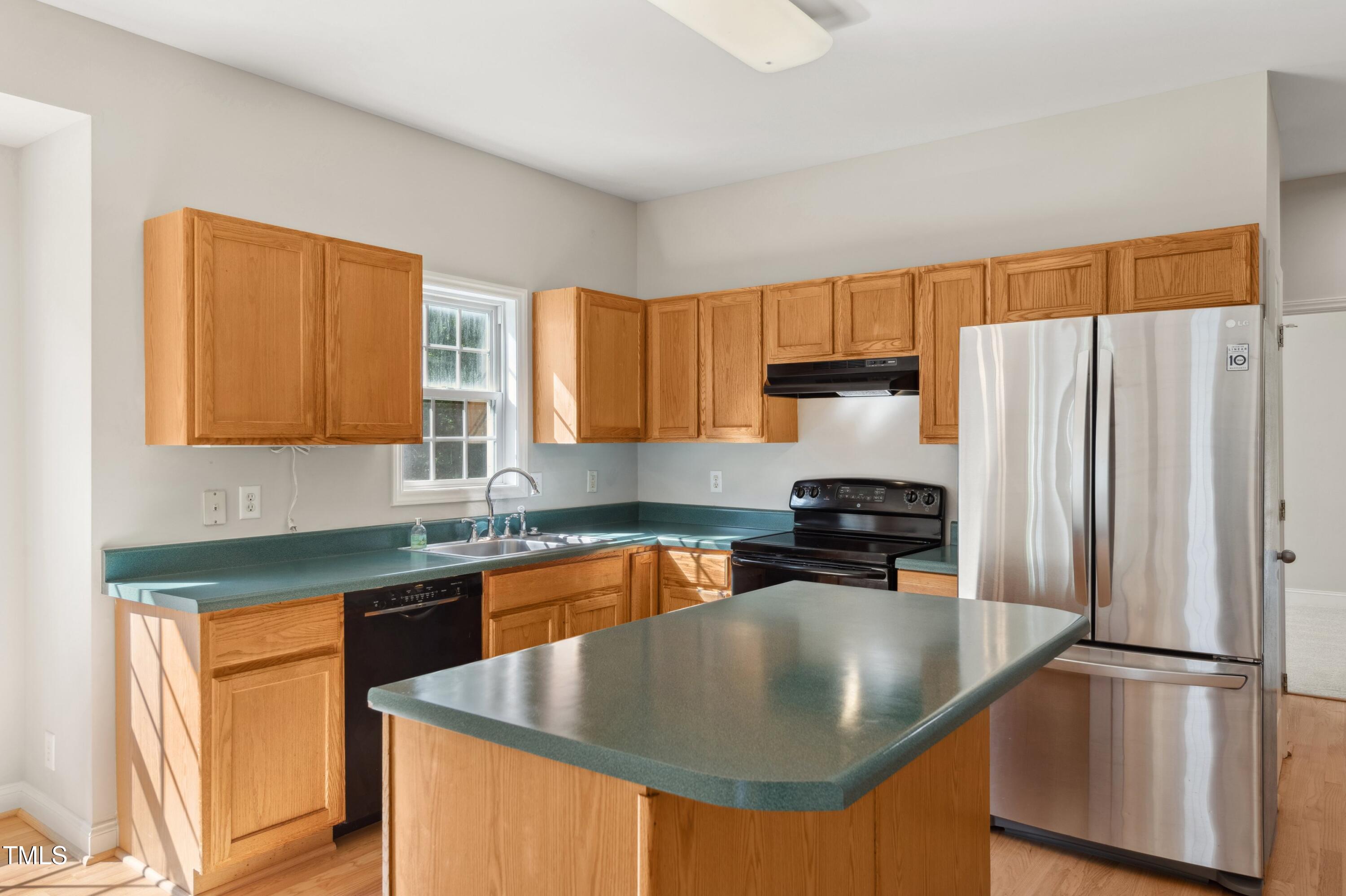 1909 Redding Lane Durham, NC 27712 - Photo 19 of 49 a kitchen with stainless steel appliances granite countertop a sink a stove and a refrigerator