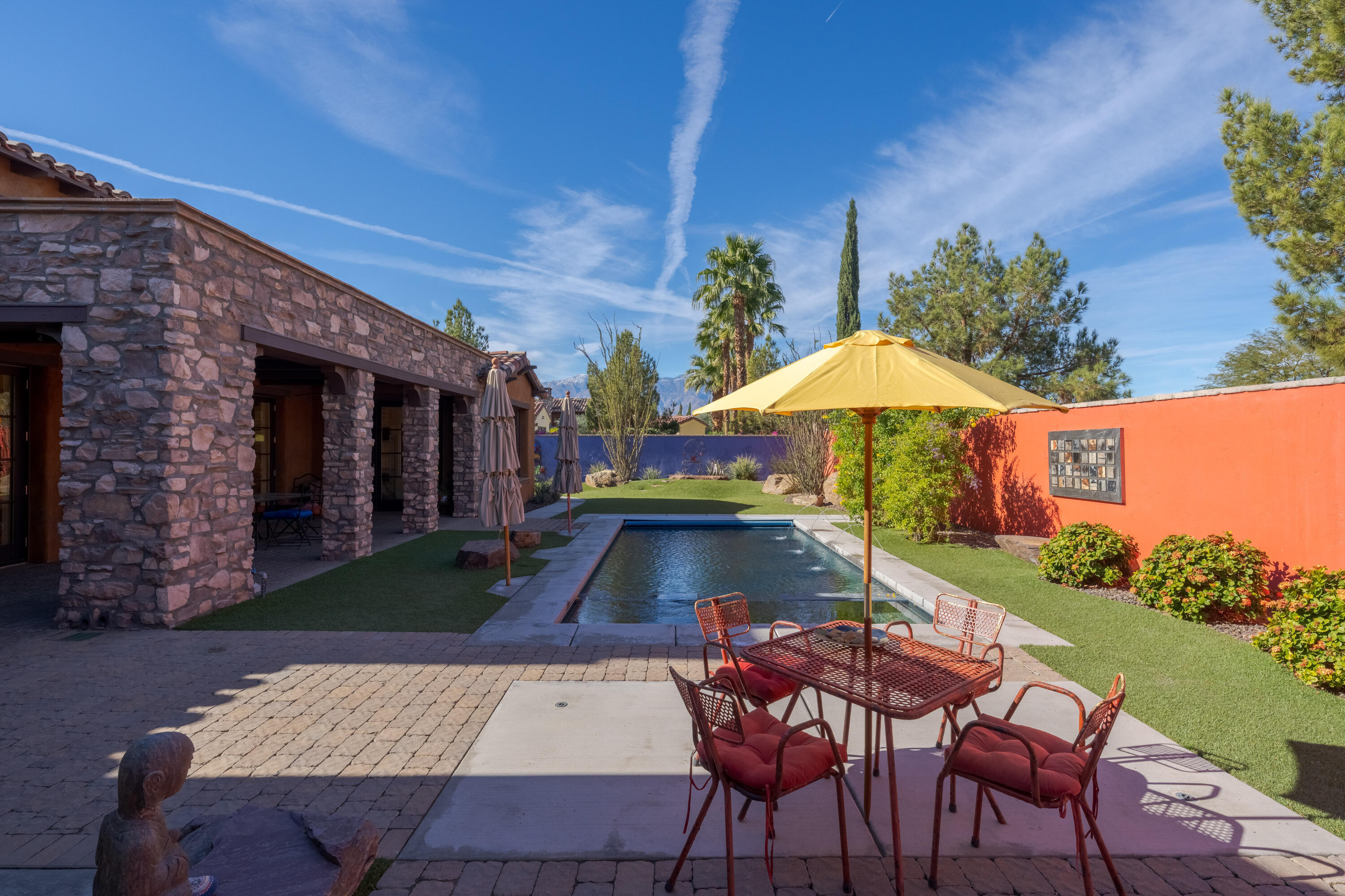 37 Cassis Circle Rancho Mirage, CA 92270 - Photo 50 of 56 a view of patio with table and chairs under an umbrella with a barbeque grill and plants
